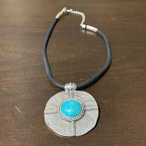 Simulated turquoise set in a distressed stainless steel pendant Necklace